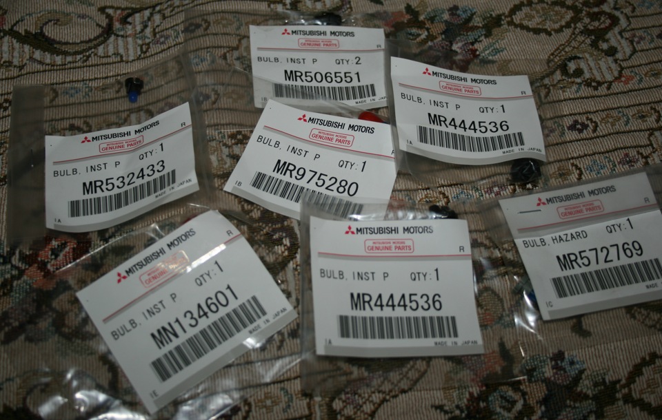 Россыпь ламп в панель. — Mitsubishi Lancer IX. Запчасти на фото: MR506551, MR444536, MR532433, MR975280, MN134601, MR572769