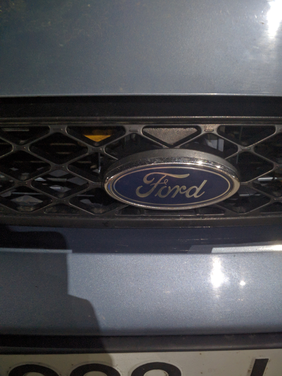 желтый наконечник лапки открытия еле виден через решетку радиатора — Ford Focus Sedan I