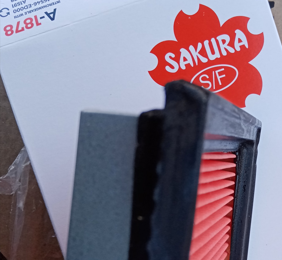Взамен был приобретен фильтр Sakura A-1878. Повелся на лестные отзывы. По факту сухой. Может он и считается типа промасленный, но никакого масла я на нем не нащупал, хотя старался. Кроме того, имеются незначительные дефекты уплотнителя (на старом фильтре ни намека на такое). Яма номер 1 на уплотнителе. Картонная упаковка фильтра без деформации и каких либо следов воздействия. — Nissan Tiida (1G). Запчасти на фото: A1878, A1507